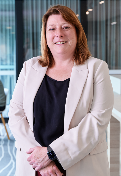 Joanne Brown smiling and posing for photograph wearing a white jacket