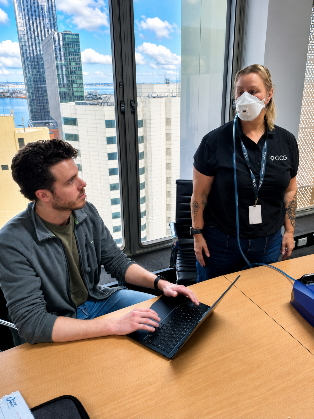 A woman being fit tested for respiratory protective equipment by an fit test expert 