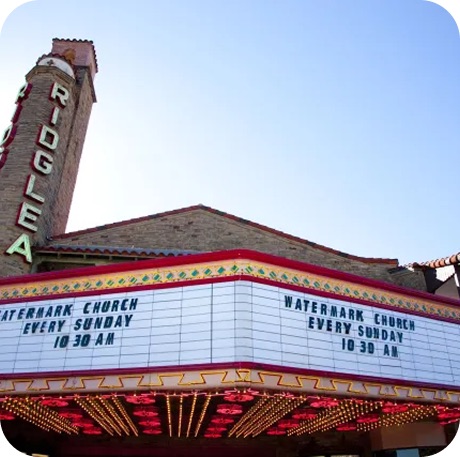 The marquee of Ridglea Theatre displaying 'Watermark Church every Sunday 10:30 AM' under a clear blue sky.