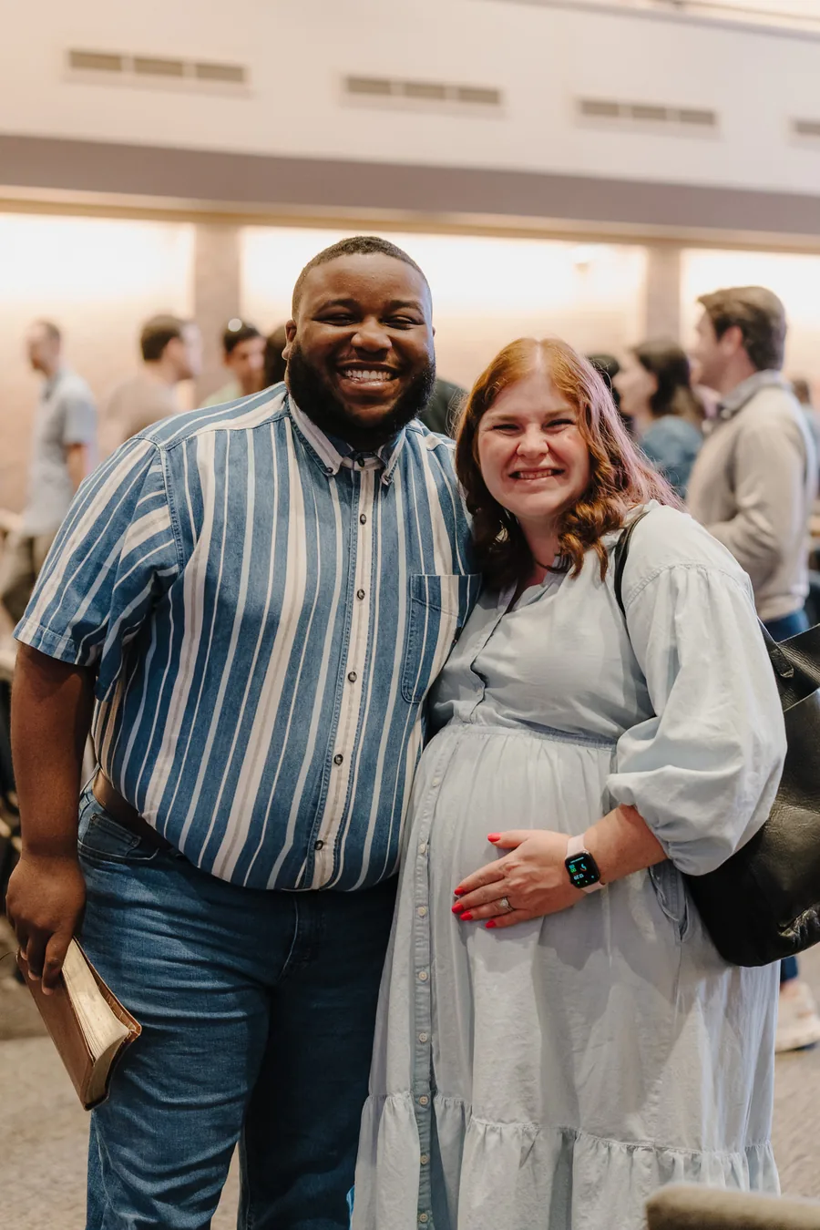 Smiling couple standing indoors.