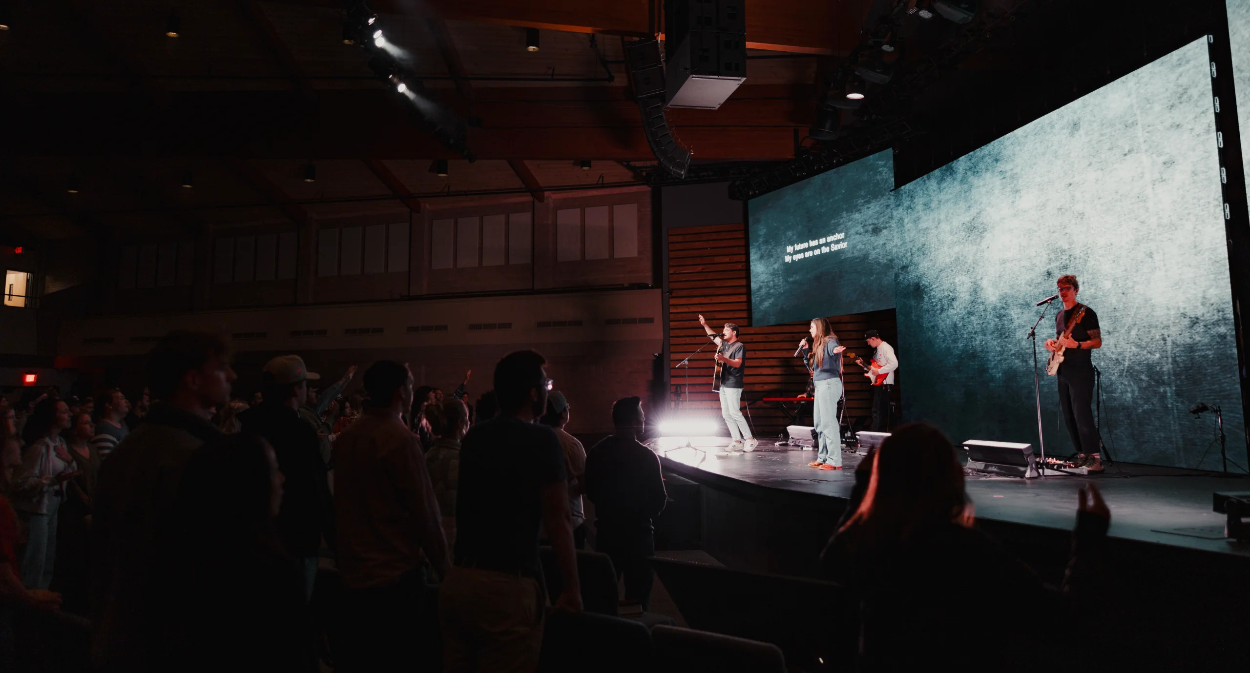 Worship team leading on stage at church gathering.