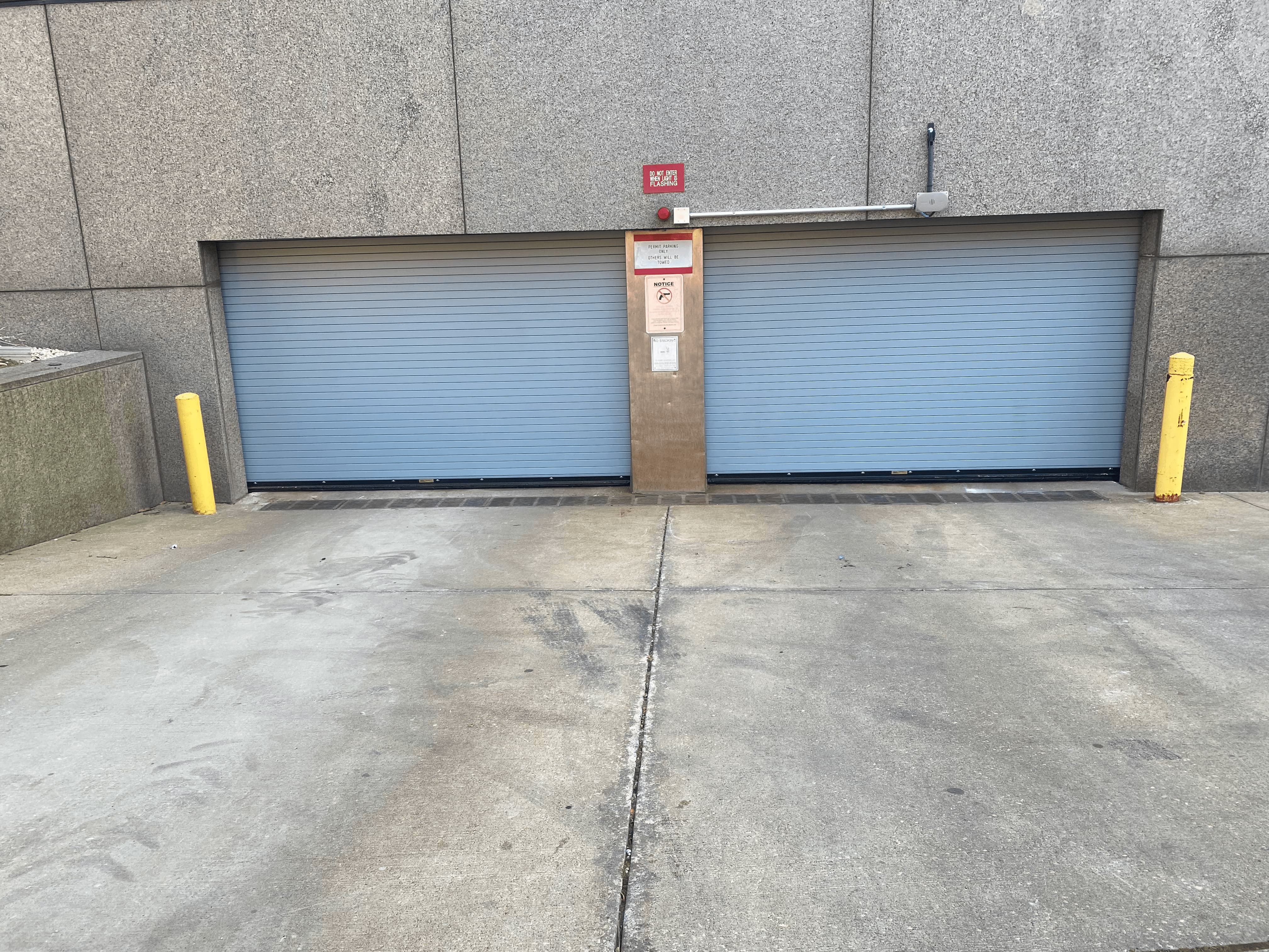 Side-by-side comparison of two garage doors on a brick building, left door is beige and weathered, right door is clean and bright white.