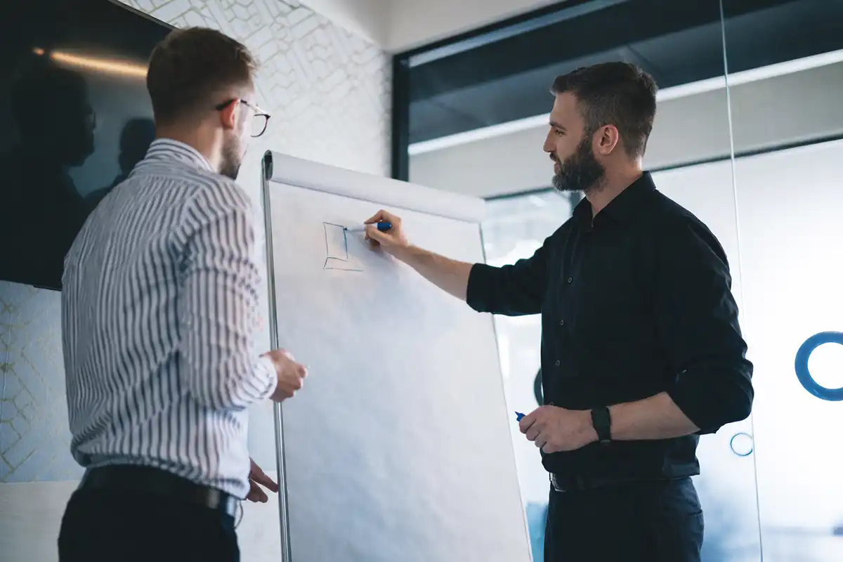 Men collaborating at whiteboard