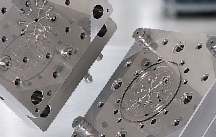 Close-up of two steel injection molds with detailed star-shaped cavity patterns on each plate.