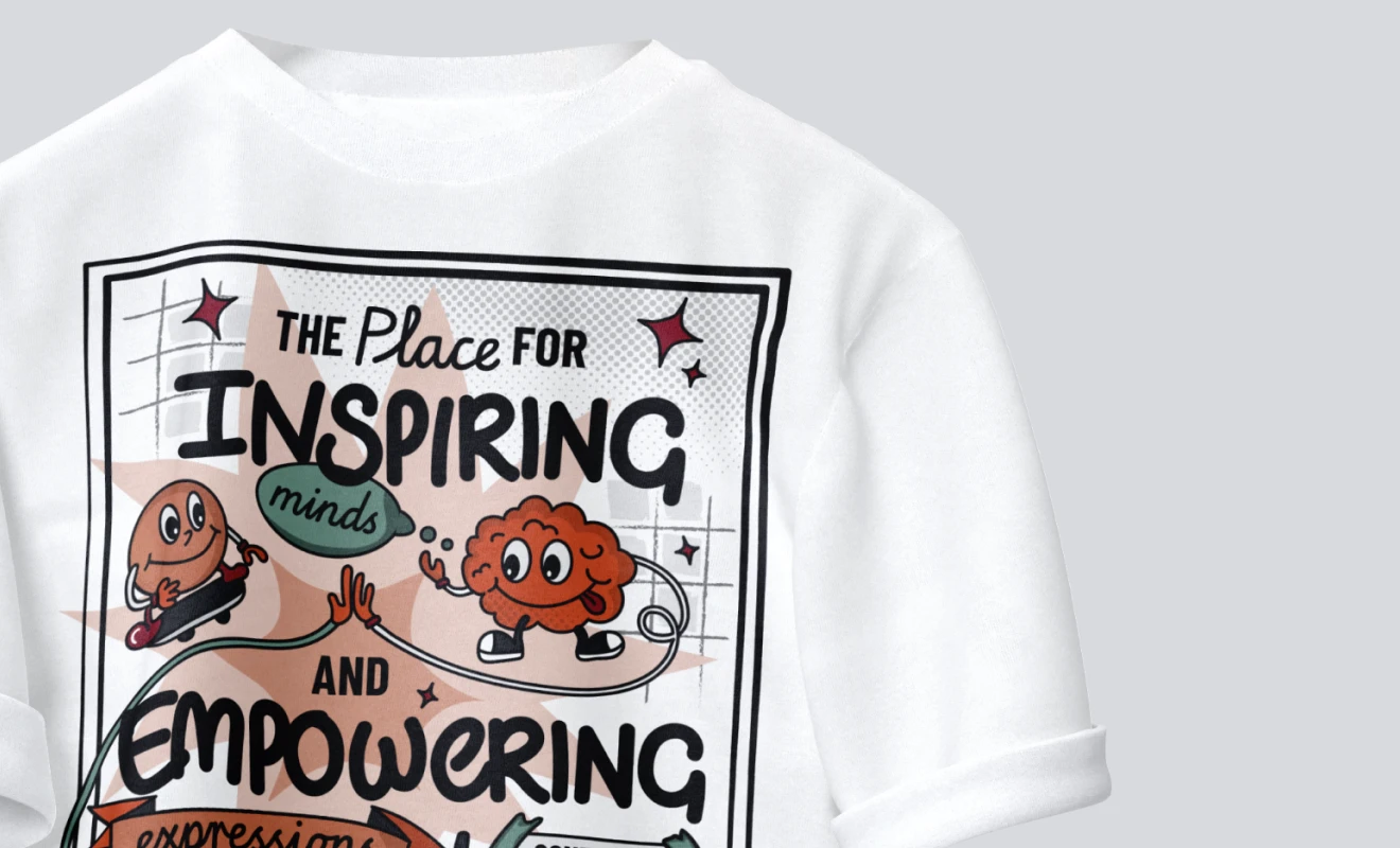 White shirt with colorful cartoon design of a brain and a character giving a high-five, with text reading 'The place for inspiring minds and empowering'.