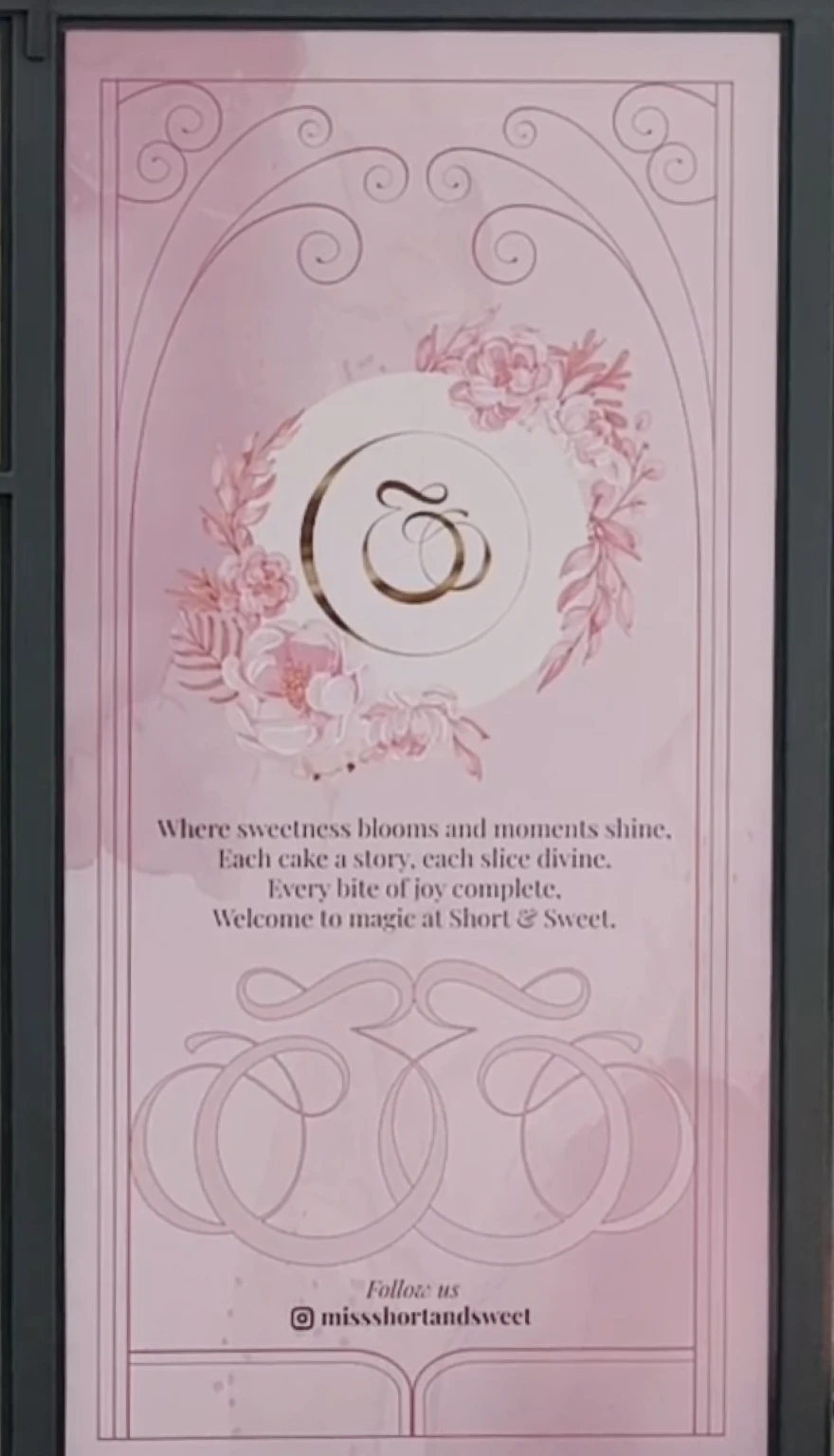 Pink poster with floral wreath and elegant script reading 'Where sweetness blooms and moments shine, Each cake a story, each slice divine. Every bite of joy complete. Welcome to magic at Short & Sweet.' Follow us on Instagram @missshortandsweet.