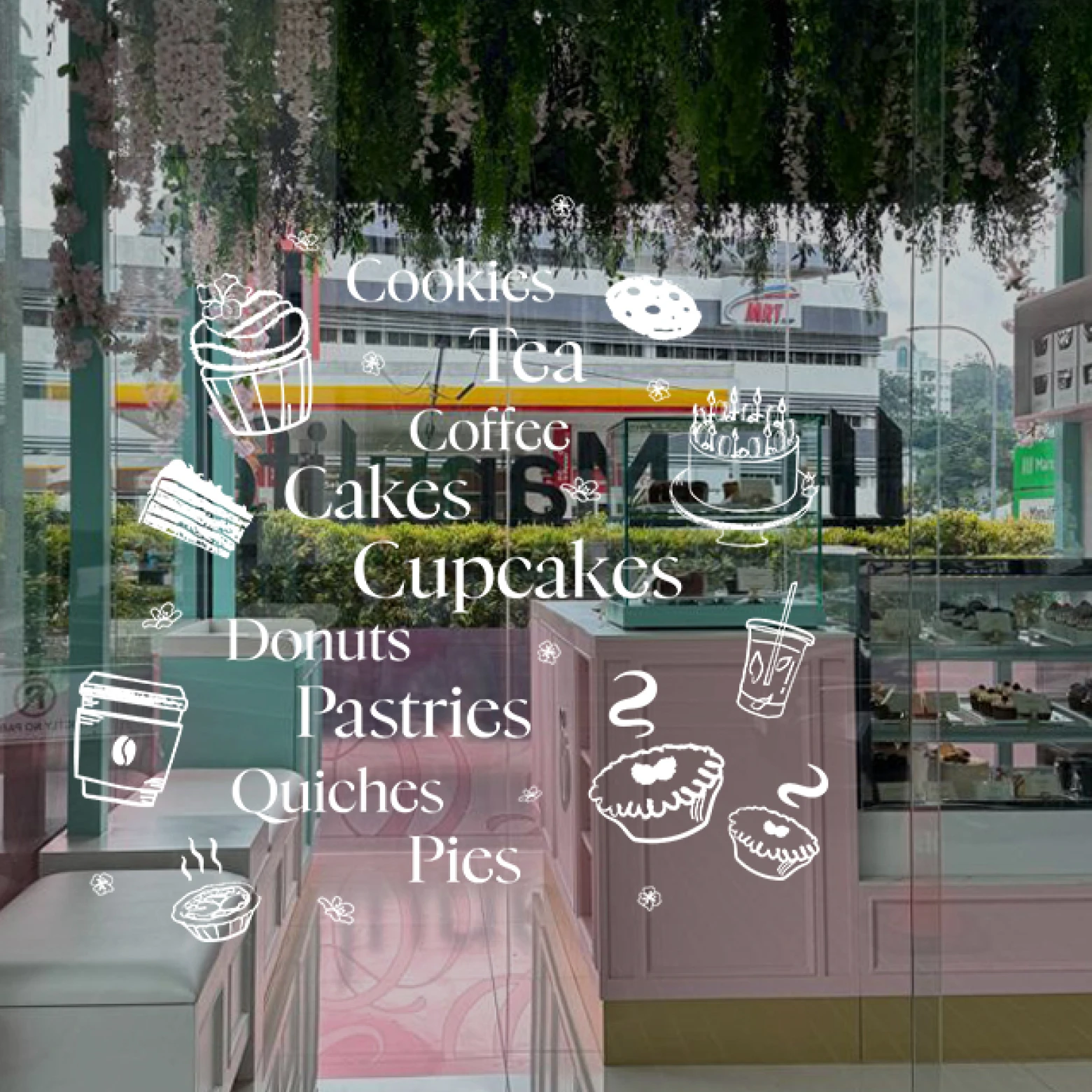 Glass door of a bakery with white illustrations of cupcakes, coffee, tea, and pastries, and words like Cookies, Tea, Coffee, Cakes, Cupcakes, Donuts, Pastries, Quiches, and Pies.
