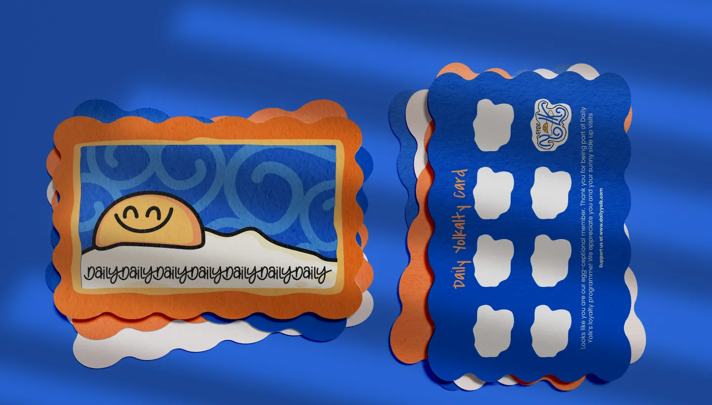 Colorful Daily Yolk loyalty cards with a smiling yolk illustration on the front and stamp slots on the back.