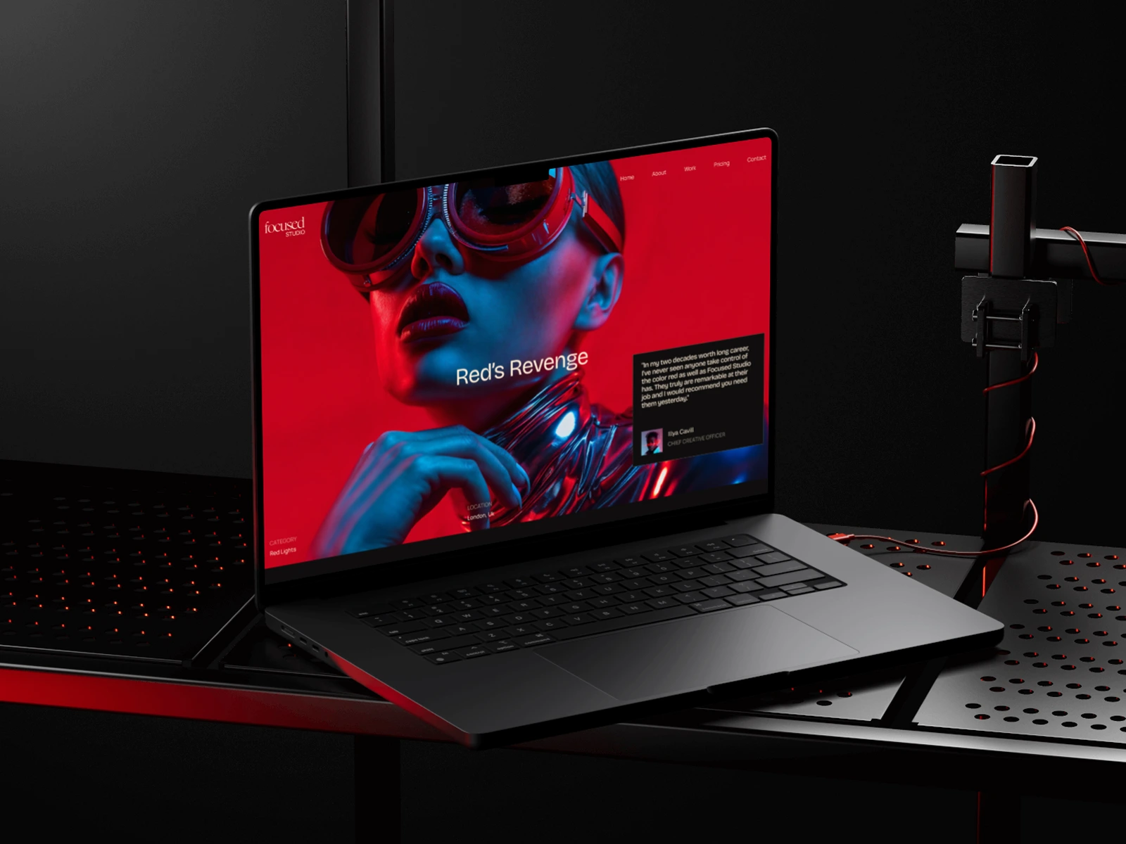 Laptop on black perforated metal table showing a red-themed website with a woman wearing large goggles from the Focused Webflow Template created by Guilty as Foxx