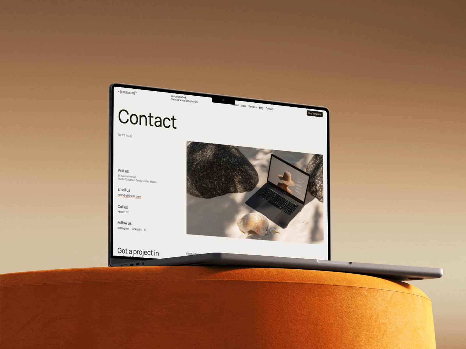 Laptop on orange cushion displaying a contact webpage from the Stillness Webflow Template created by Guilty as Foxx
