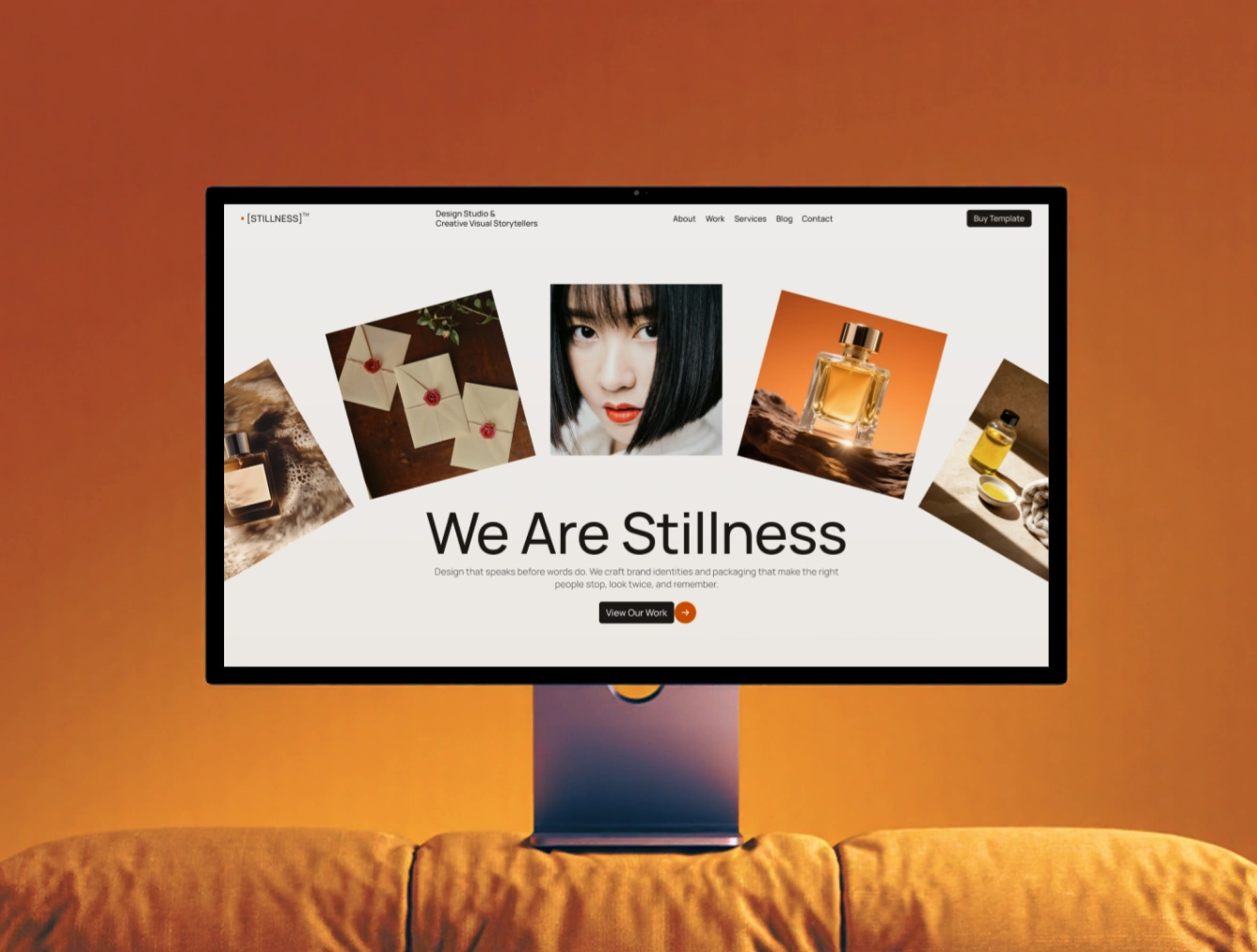 Computer monitor on orange couch showing the Stillness Webflow Template created by Guilty as Foxx