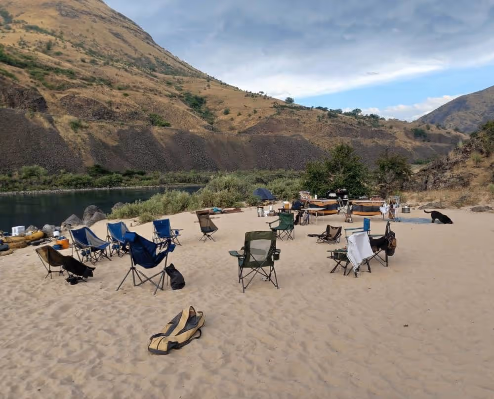 A group of lawn chairs sitting on top of a sandy beach.