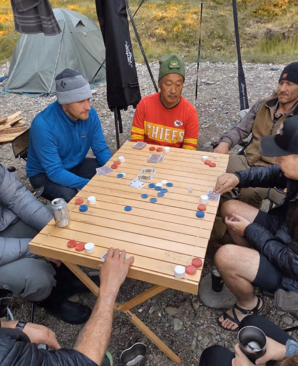 A group of men sitting around a wooden table.