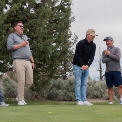 A group of men standing on top of a green field.