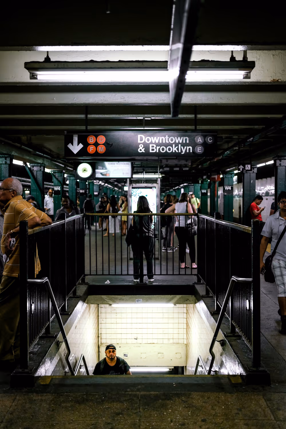 A group of people standing around a subway station.