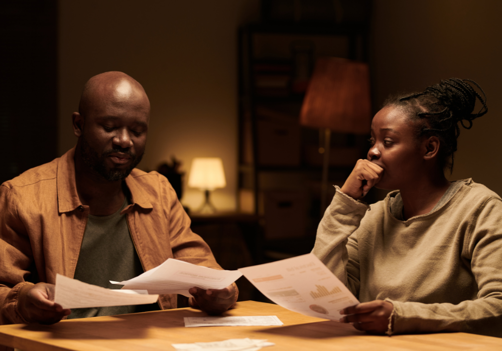 2 people reading documents at a table