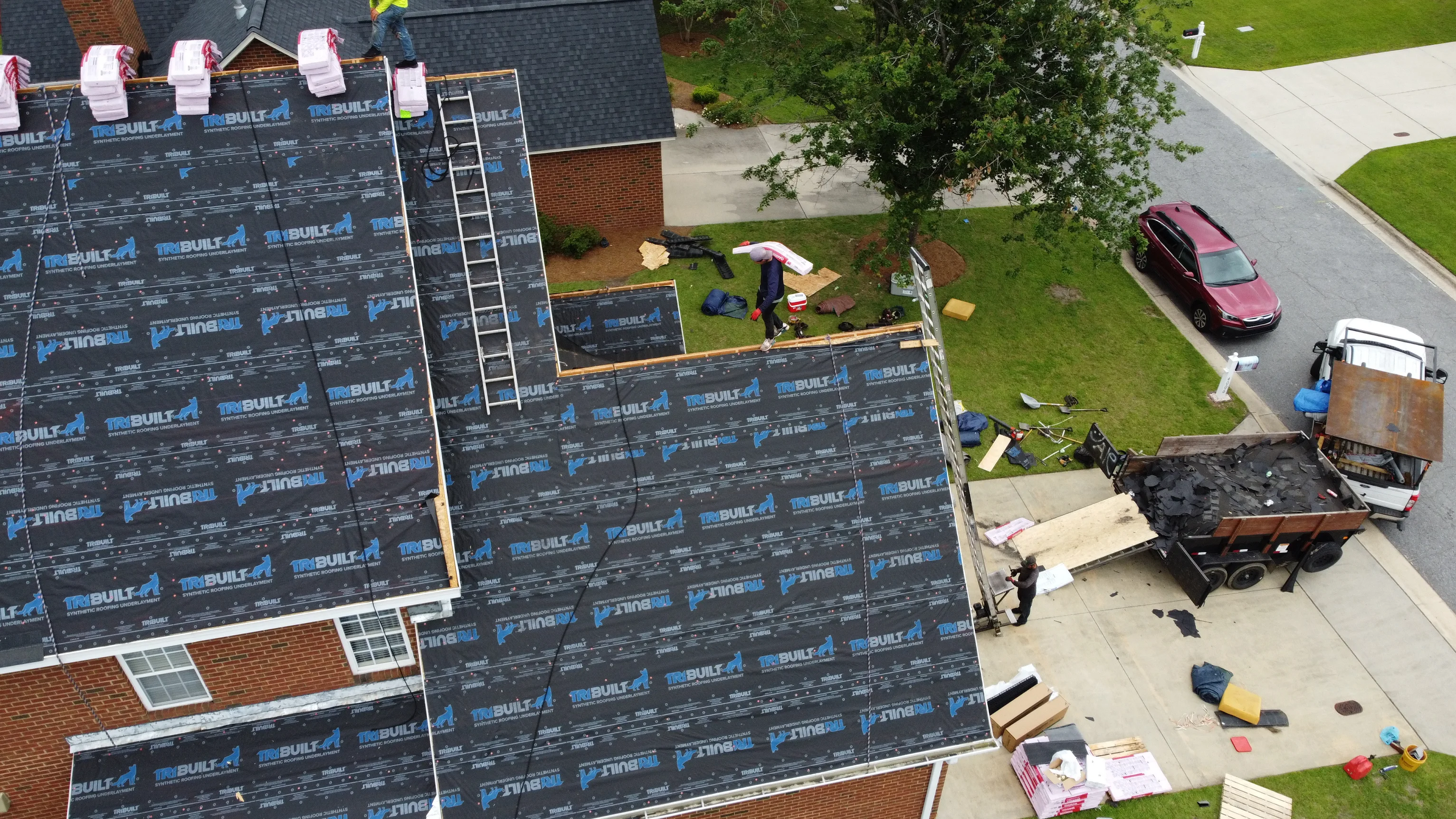 An overhead shot of a roof being replaced on a multi-story brick house in Greenville NC