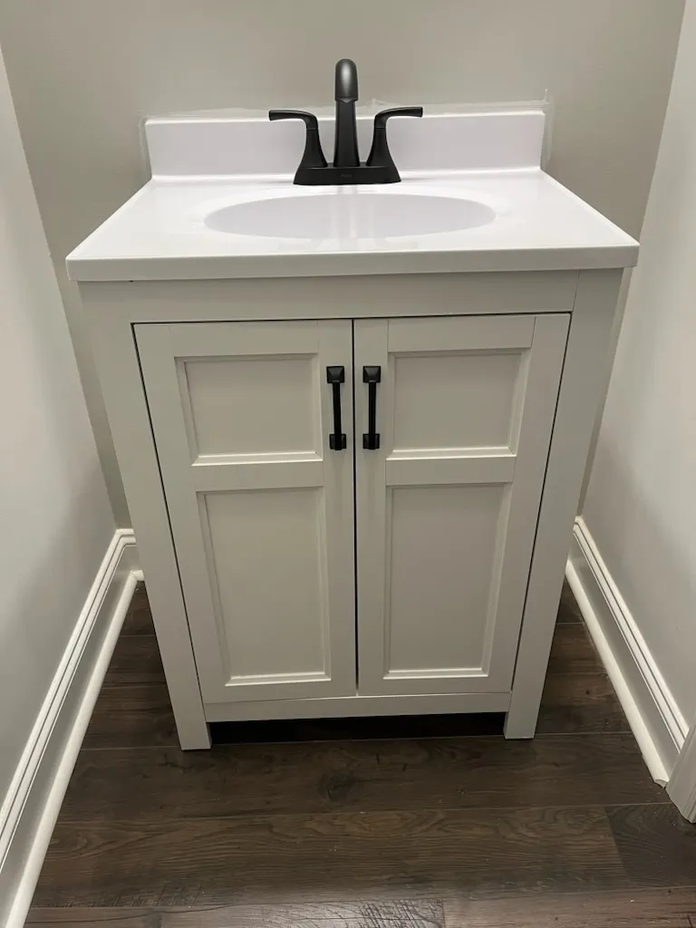 A bathroom sink vanity that has replaced the old bathroom sink