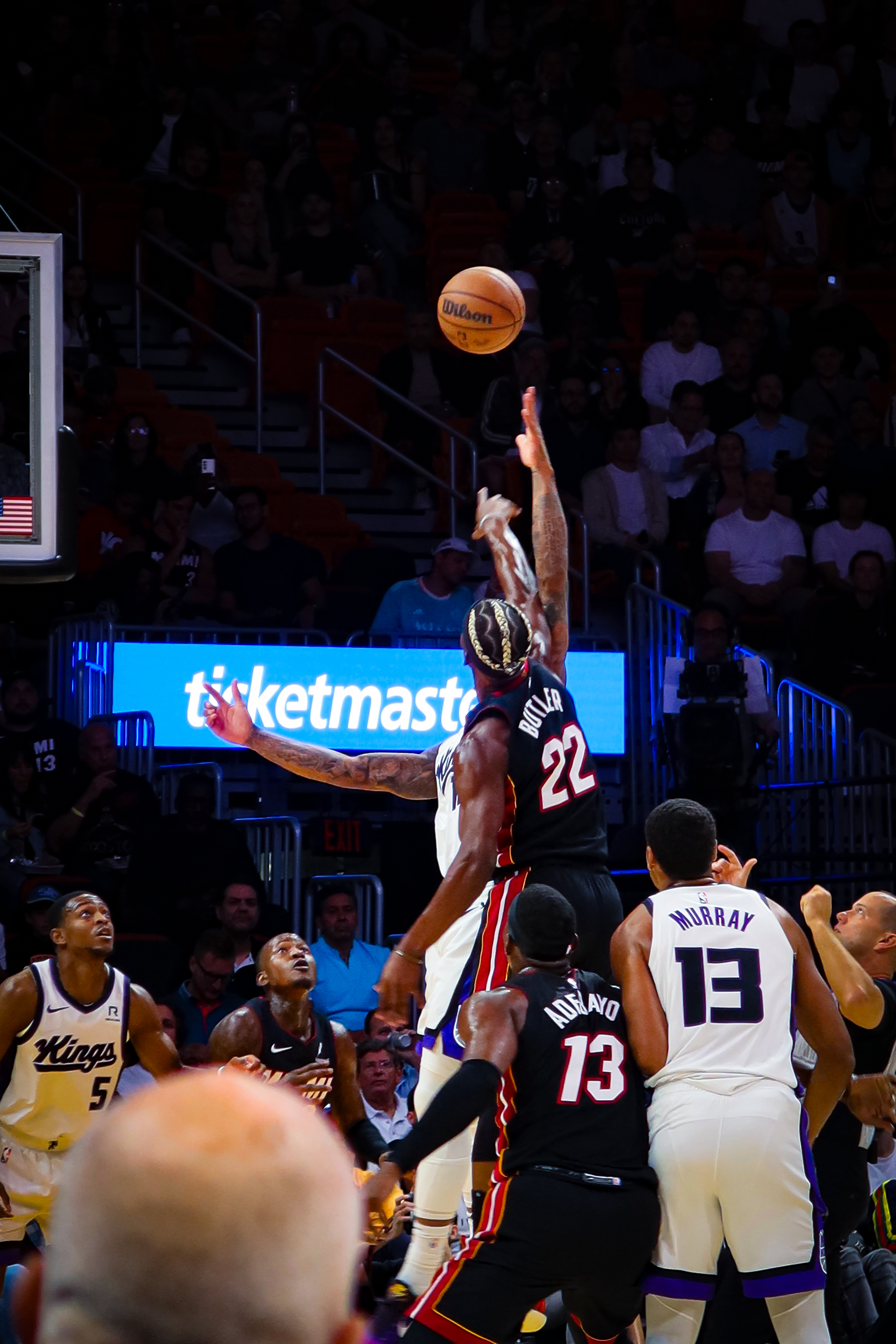 Miami Heat player Jimmy Butler leaps to shoot a basketball over Sacramento Kings defenders during a game.