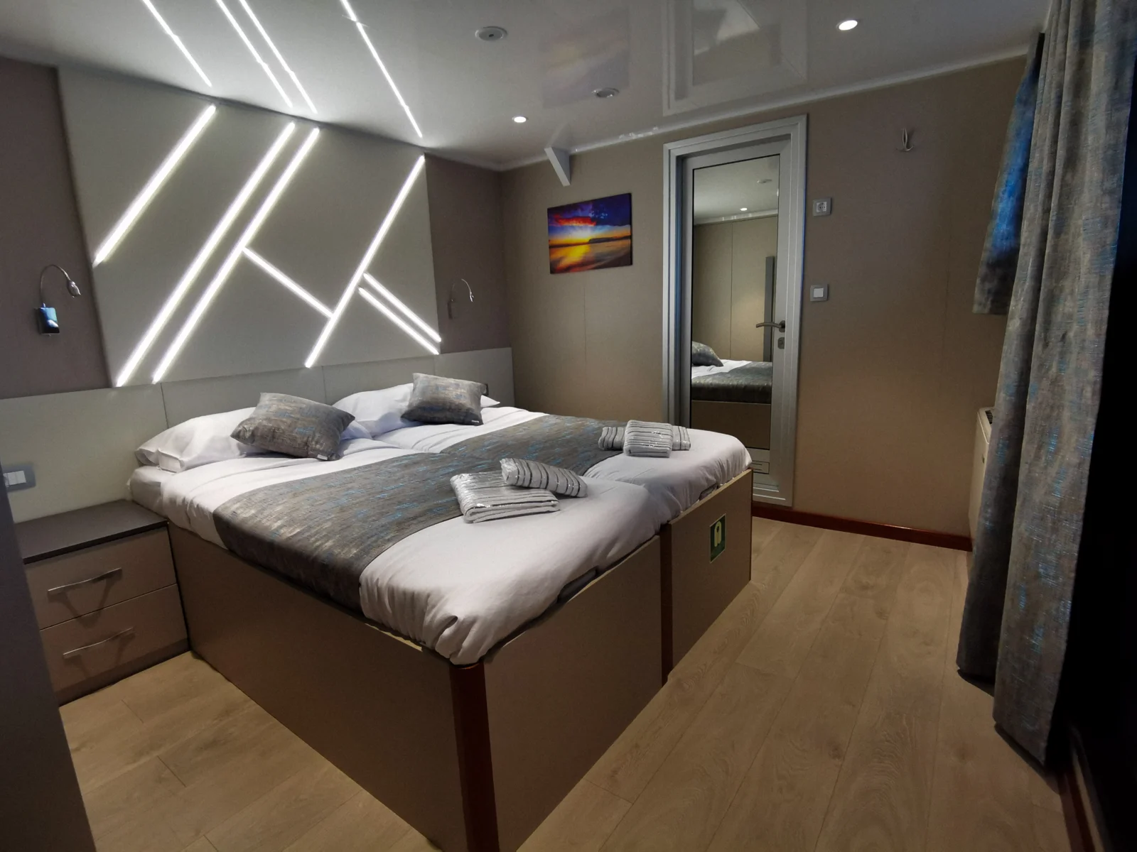Cabin with double bed, grey cushions and angled LED lighting