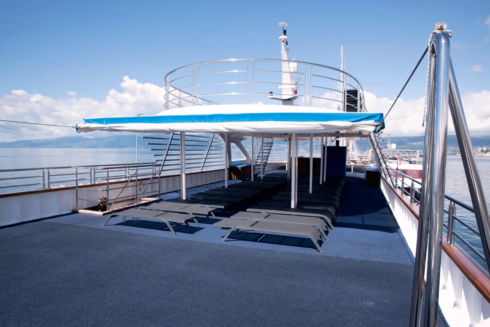 Top sun deck with loungers and blue shade canopy