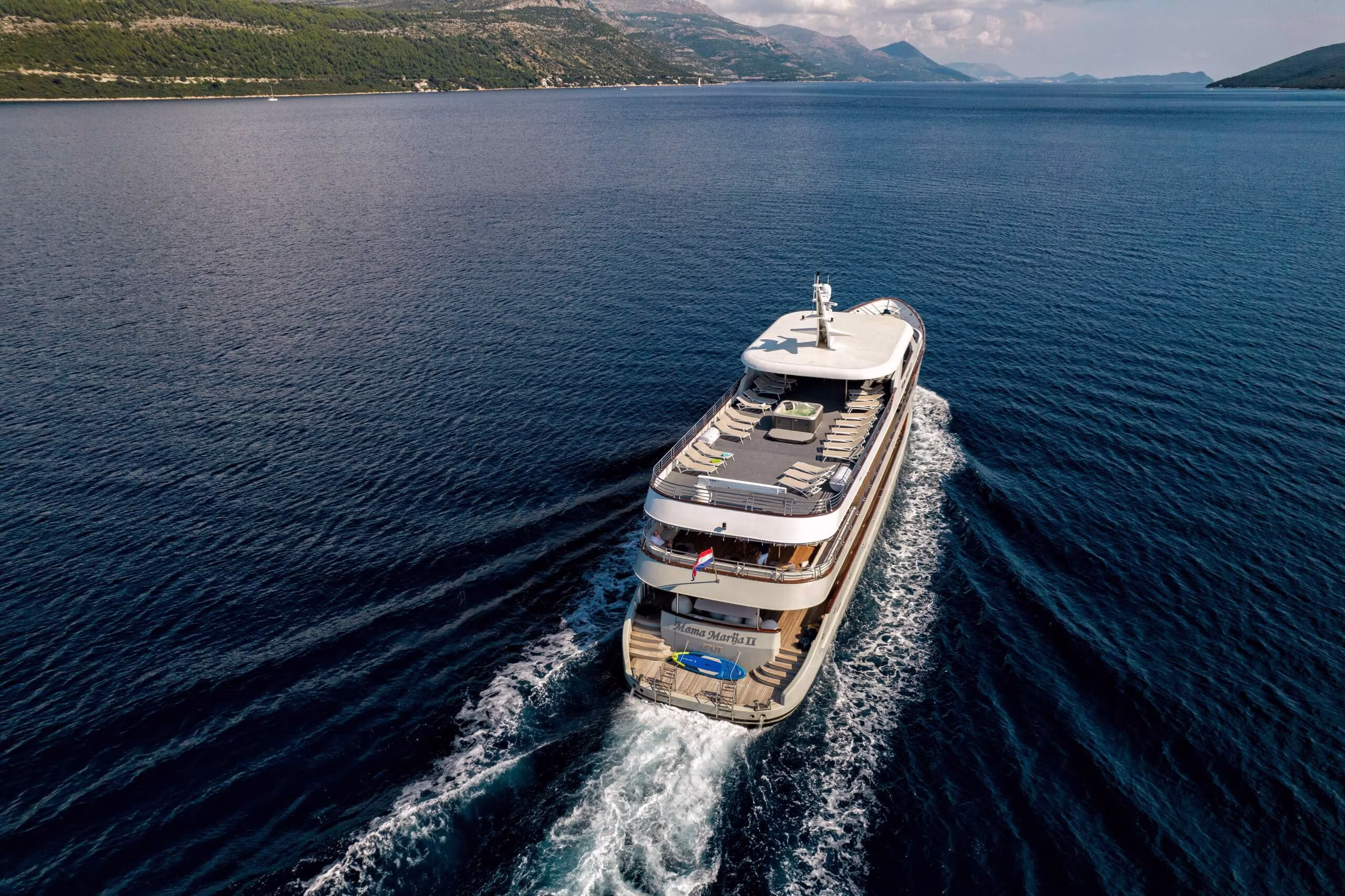 Cruise ship leaving a white wake across dark blue water