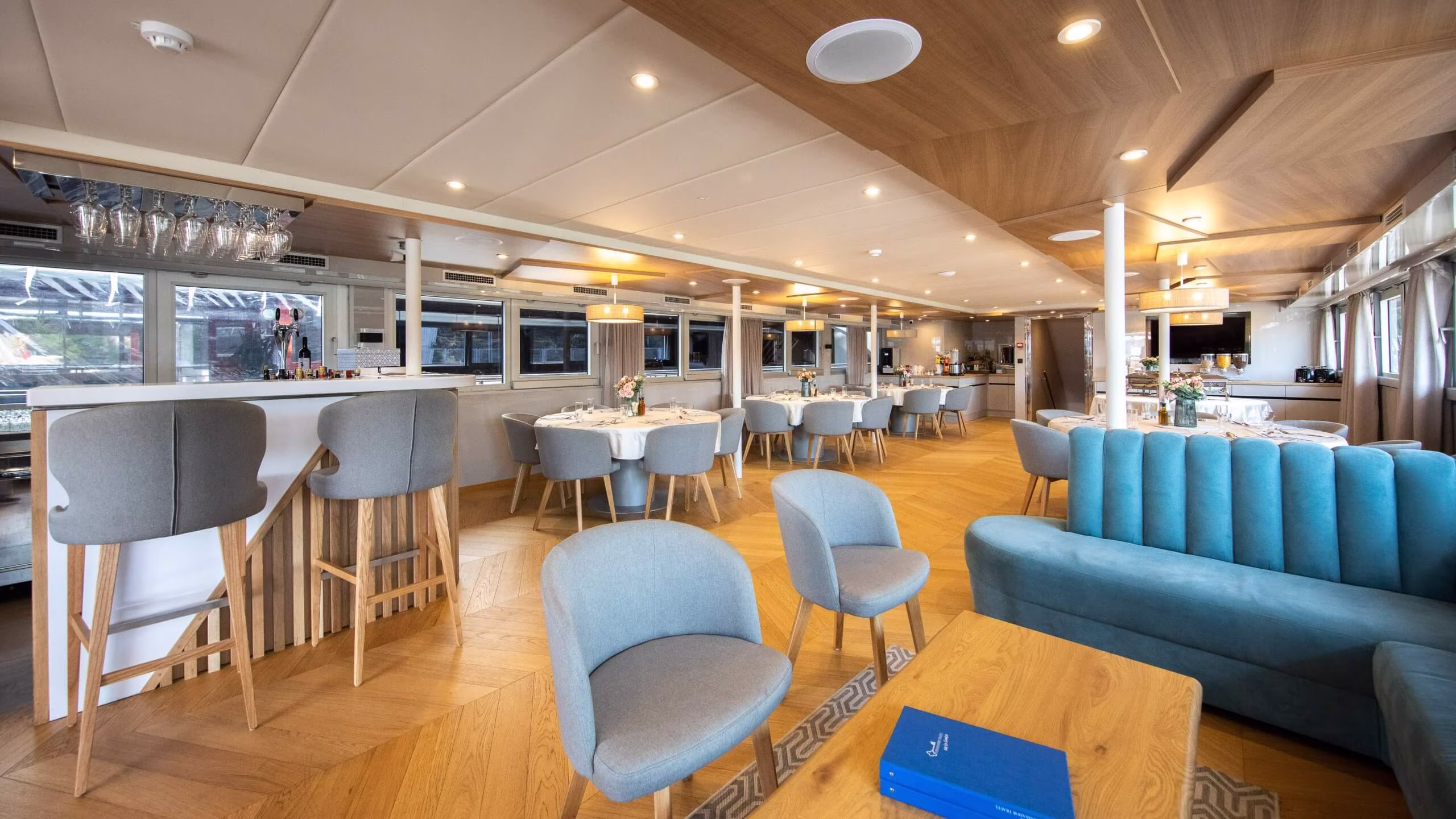 Bar and dining area with blue chairs and wooden ceiling