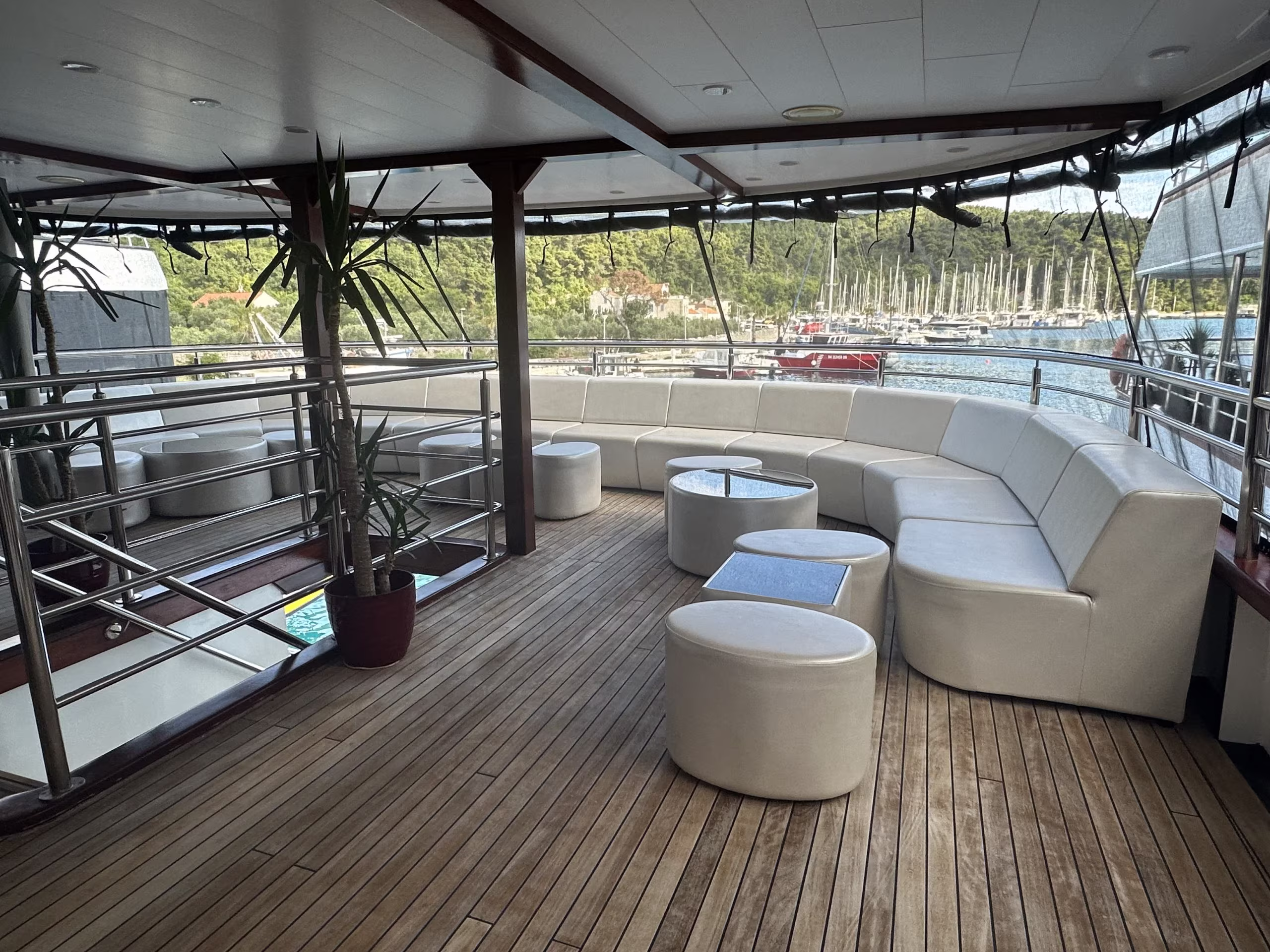 Covered deck with curved white sofas and pouffes