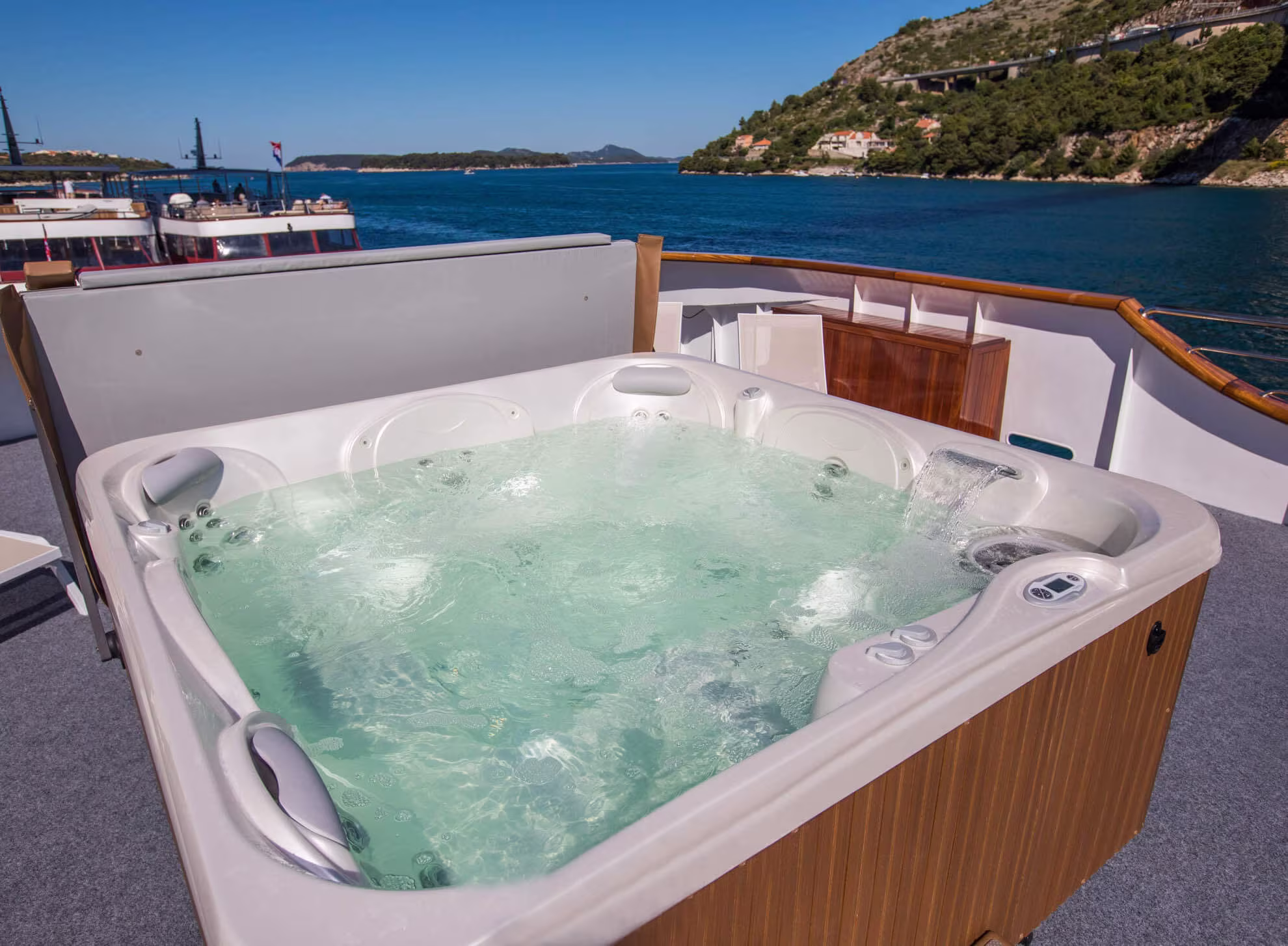 Deck hot tub with views of the green coastline