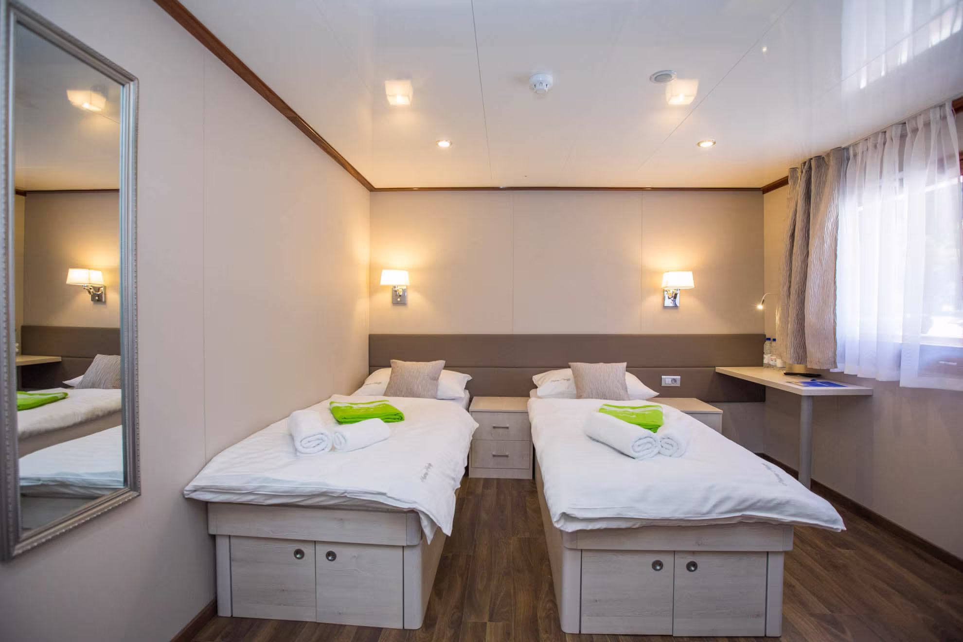 Twin cabin with single beds and green towels