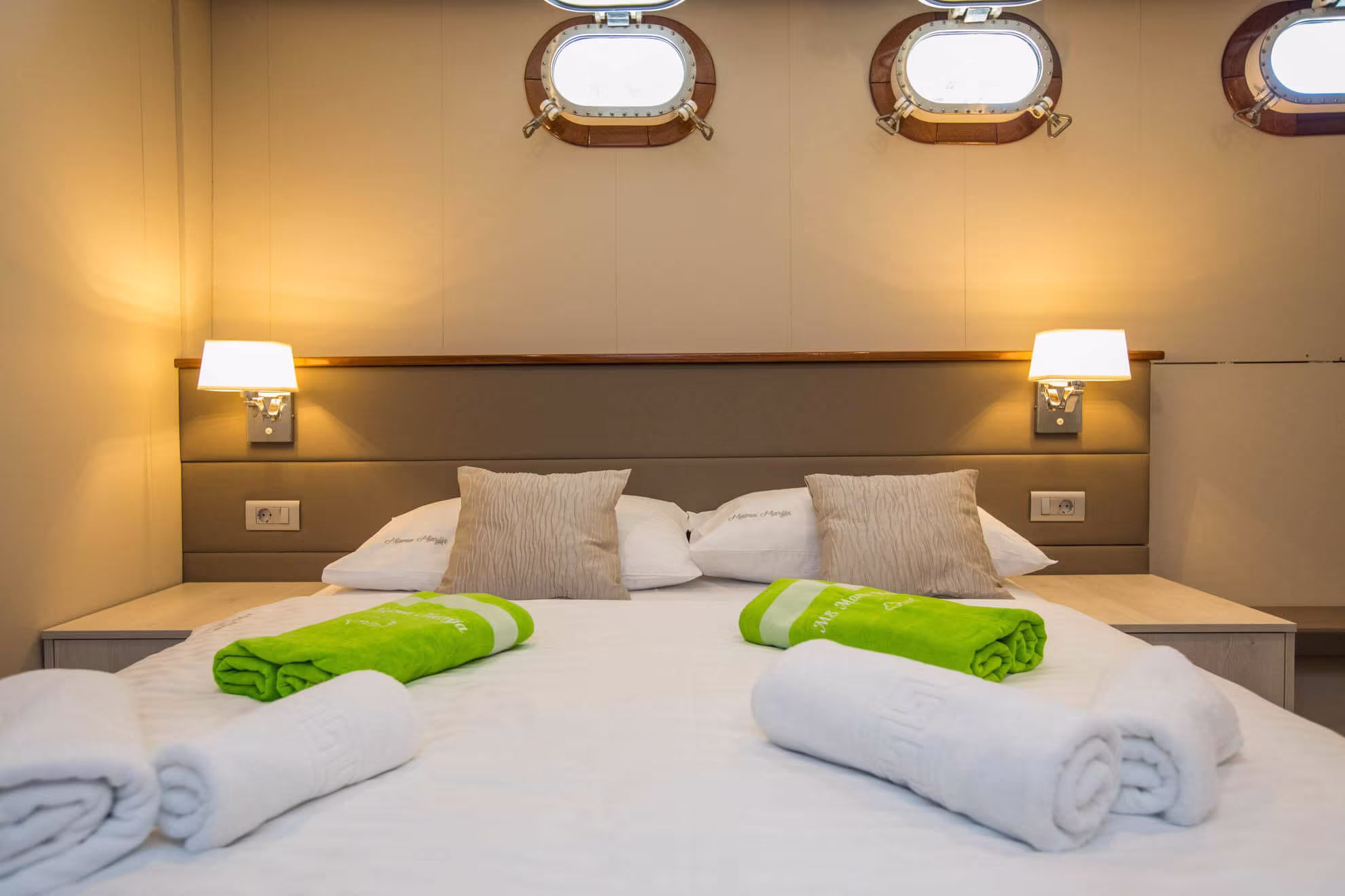 Double cabin with portholes, reading lamps and green towels