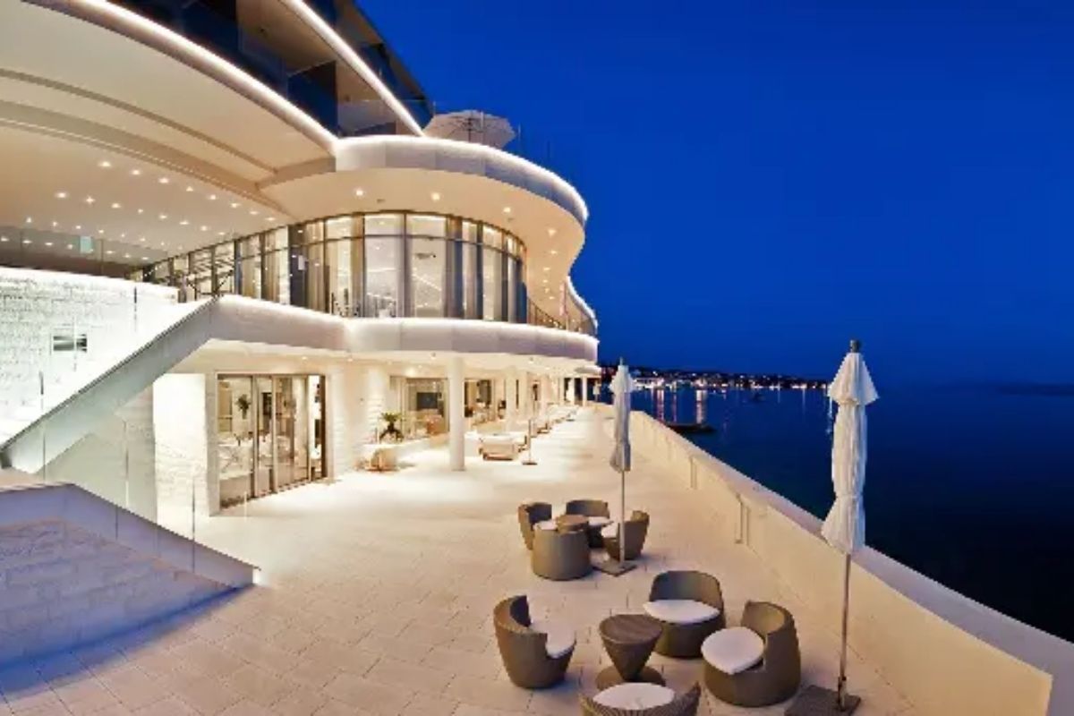 Hotell Amabilis curved terrace with lounge chairs at dusk