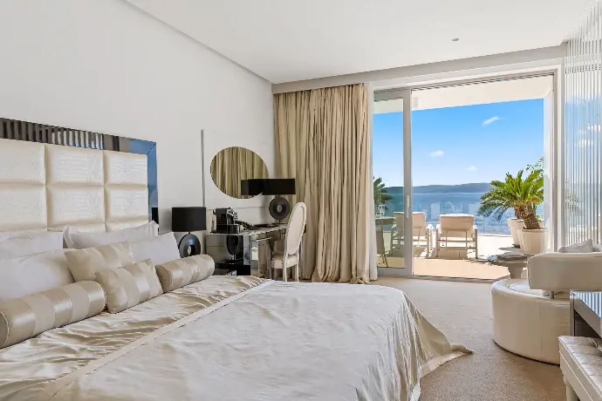 Hotell Amabilis bedroom with balcony doors, potted palm and sea view
