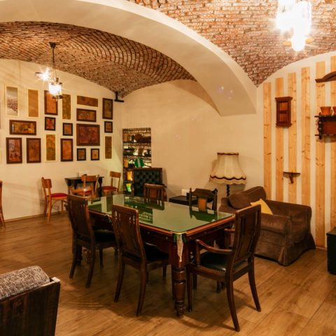 Hotel Jagerhorn lounge with vaulted ceiling, dining table and framed pictures
