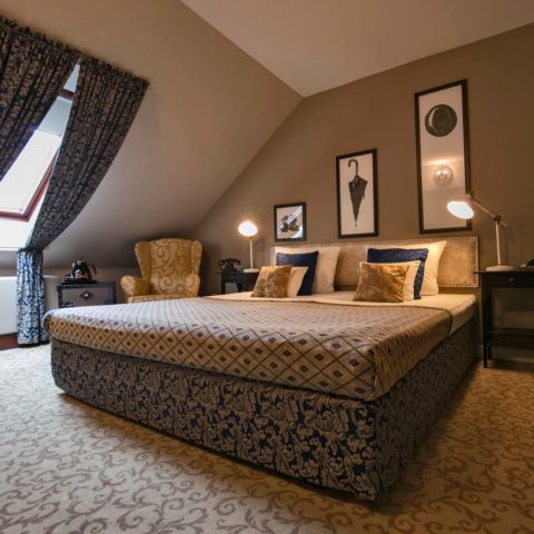 Hotel Jagerhorn attic double bedroom with sloped ceiling and armchair