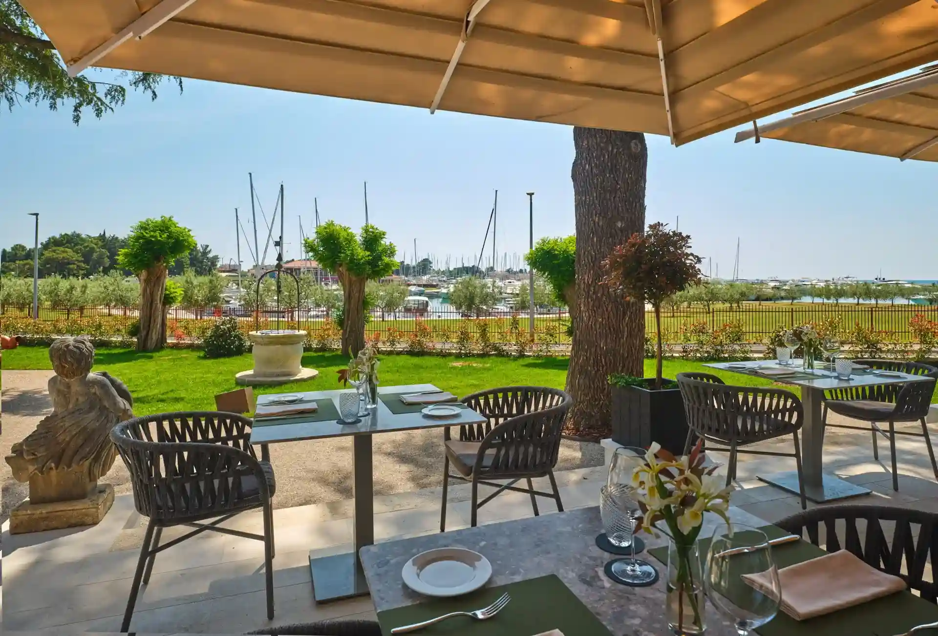 Palazzo Rainis Hotel & Spa terrace tables with palm trees and lawn