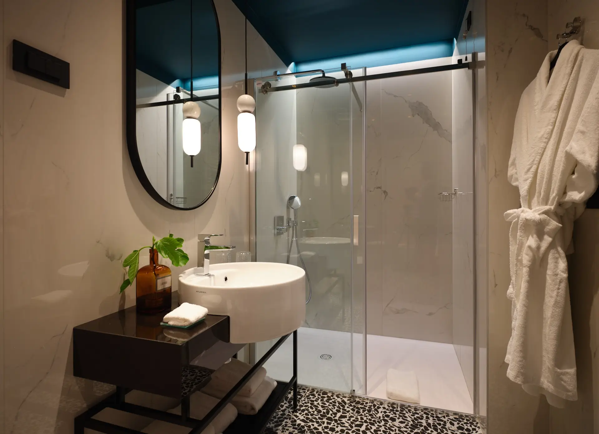 Palazzo Rainis Hotel & Spa bathroom with glass shower, round mirror and bathrobe