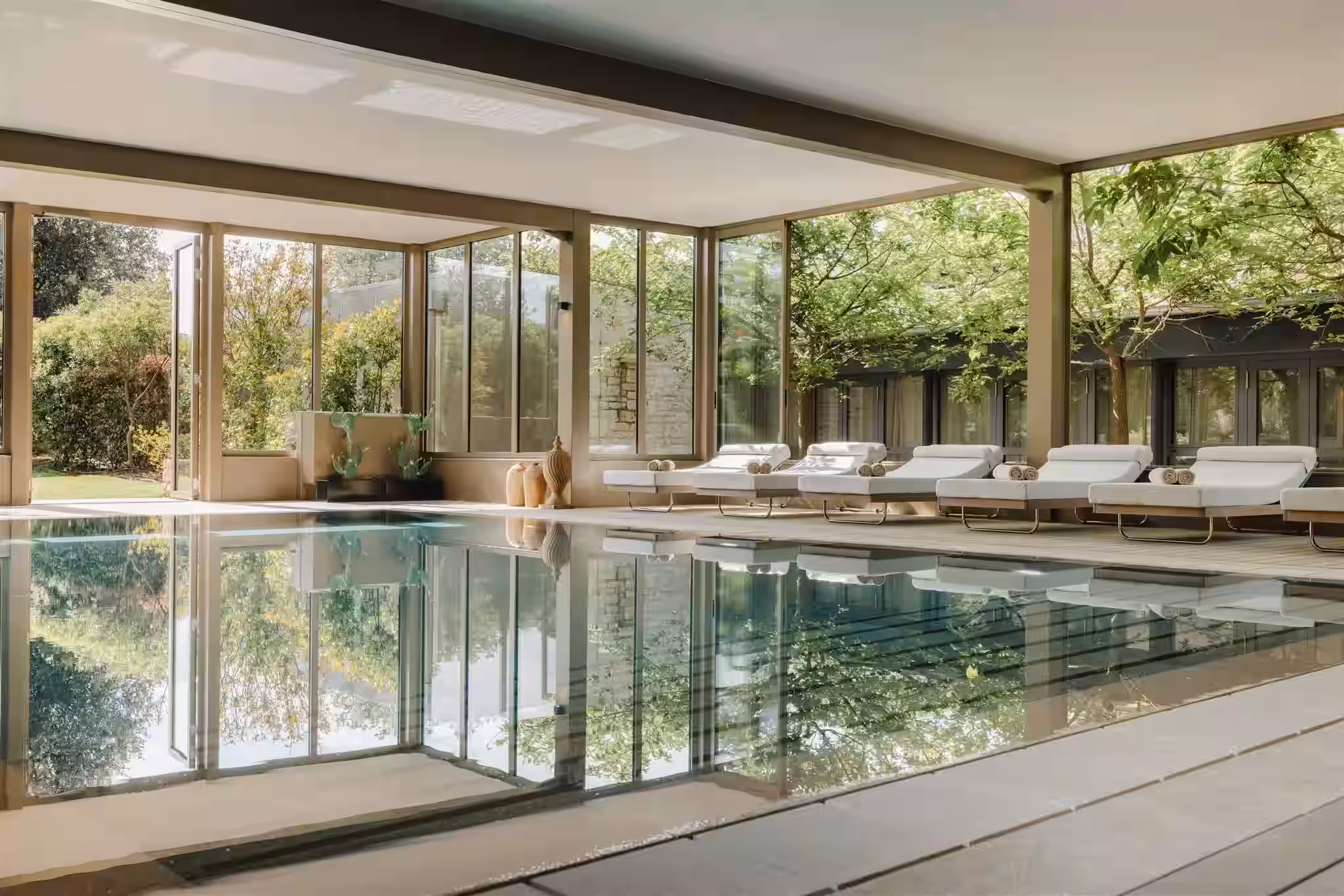 Meneghetti glass-walled indoor pool with loungers