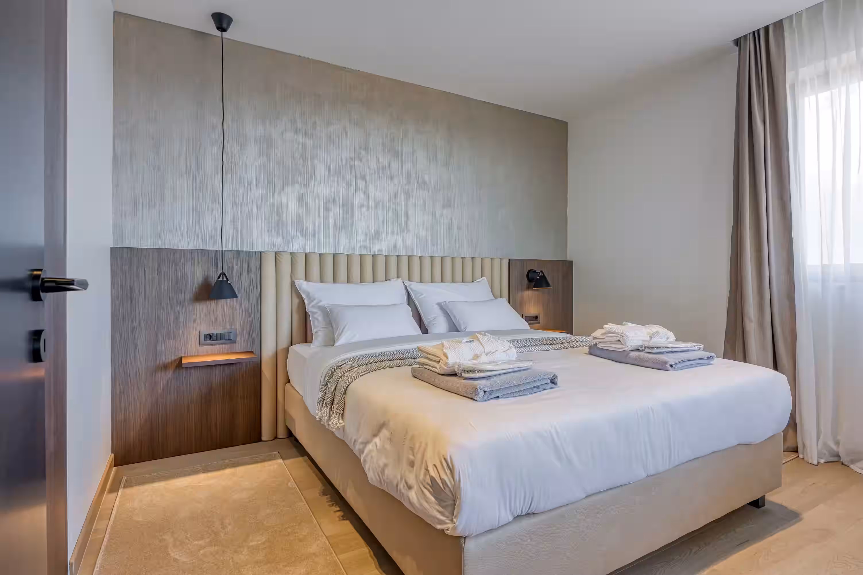 Level 5 Rovinj bedroom with towels on the bed and wood panel wall