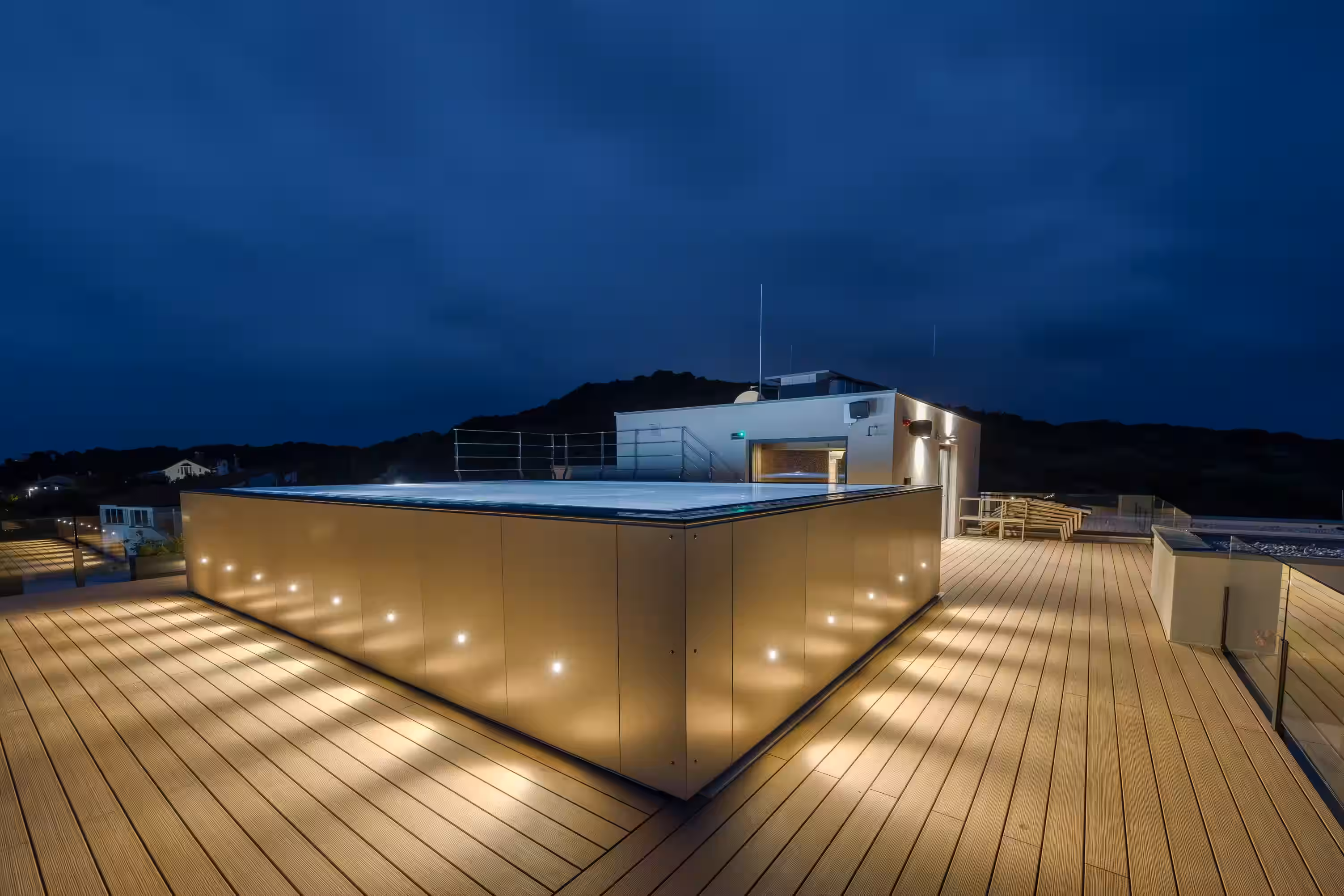 Level 5 Rovinj rooftop deck with lit planters at dusk