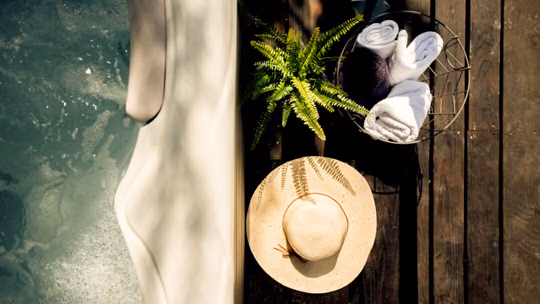 Oreskovic Guest House straw hat and rolled towels beside a potted plant