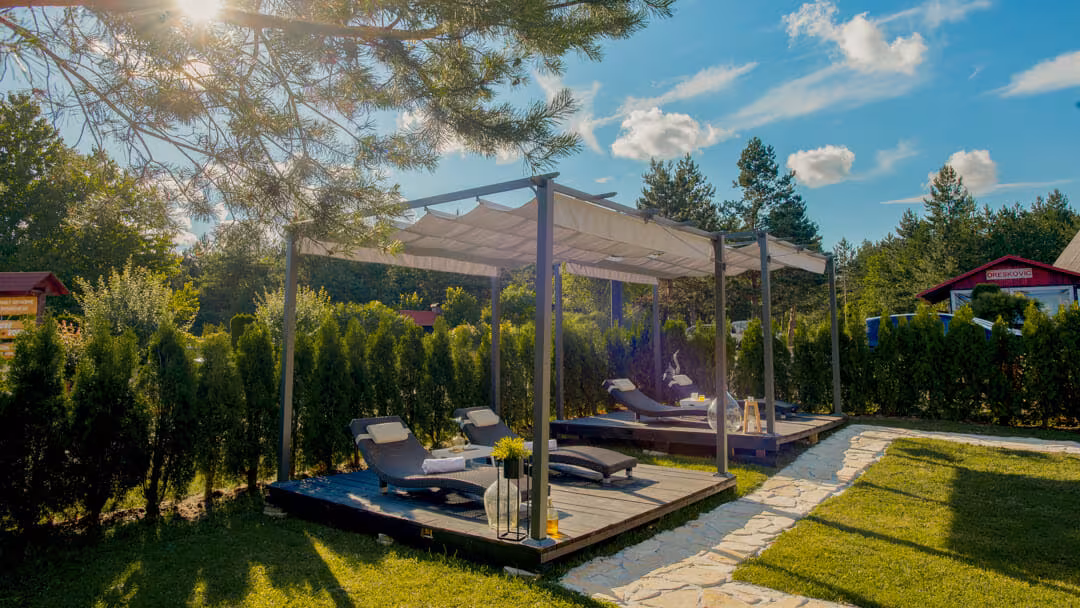 Oreskovic Guest House garden pergola with loungers among trees