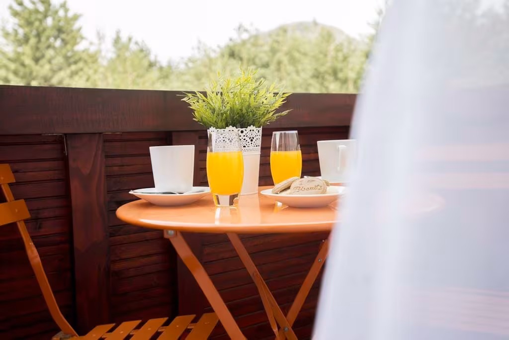 Oreskovic Guest House balcony table with orange juice and breakfast