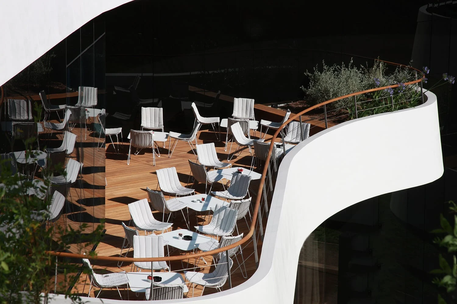 Lone curved terrace with white lounge chairs seen from above