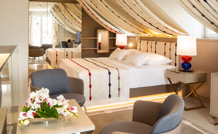 Lemongarden Boutique Hotel bedroom with striped fabric ceiling, armchairs and white roses