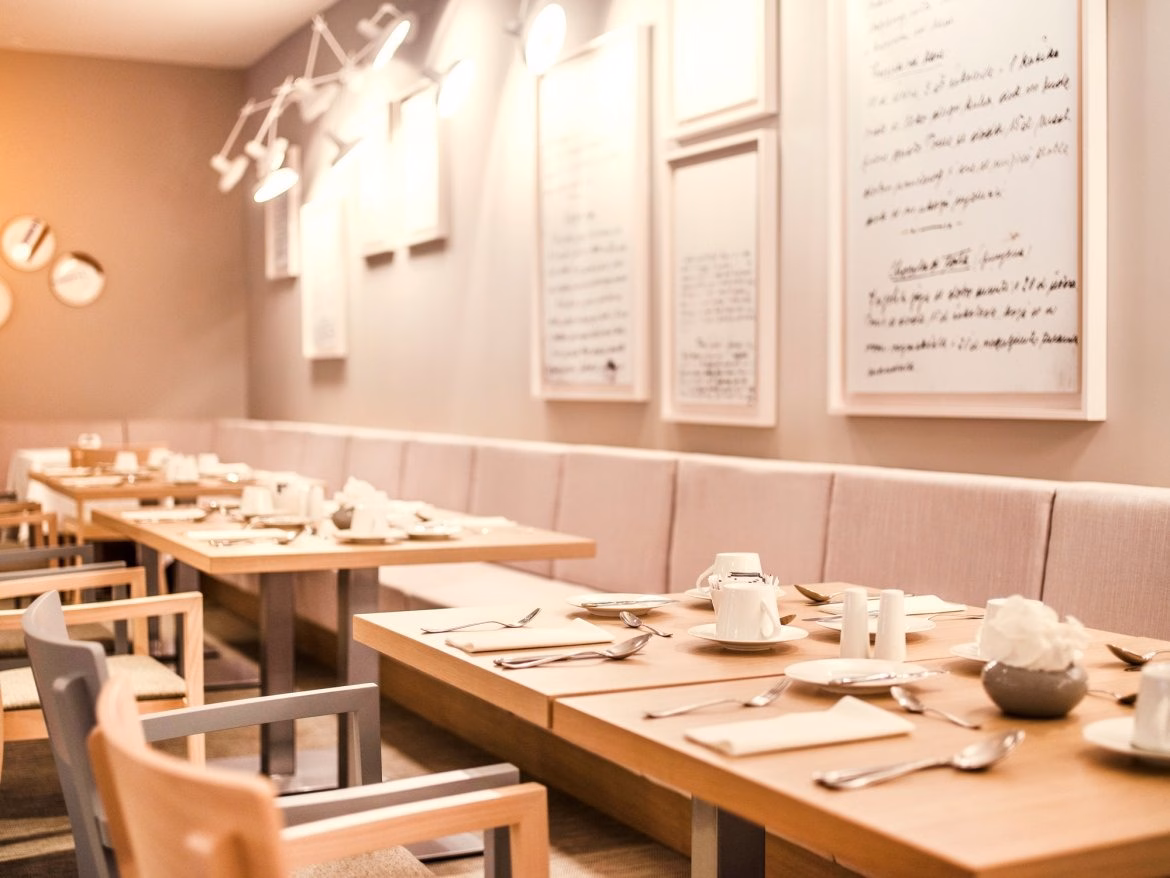 Kompas Hotel dining room with set tables and handwritten wall art