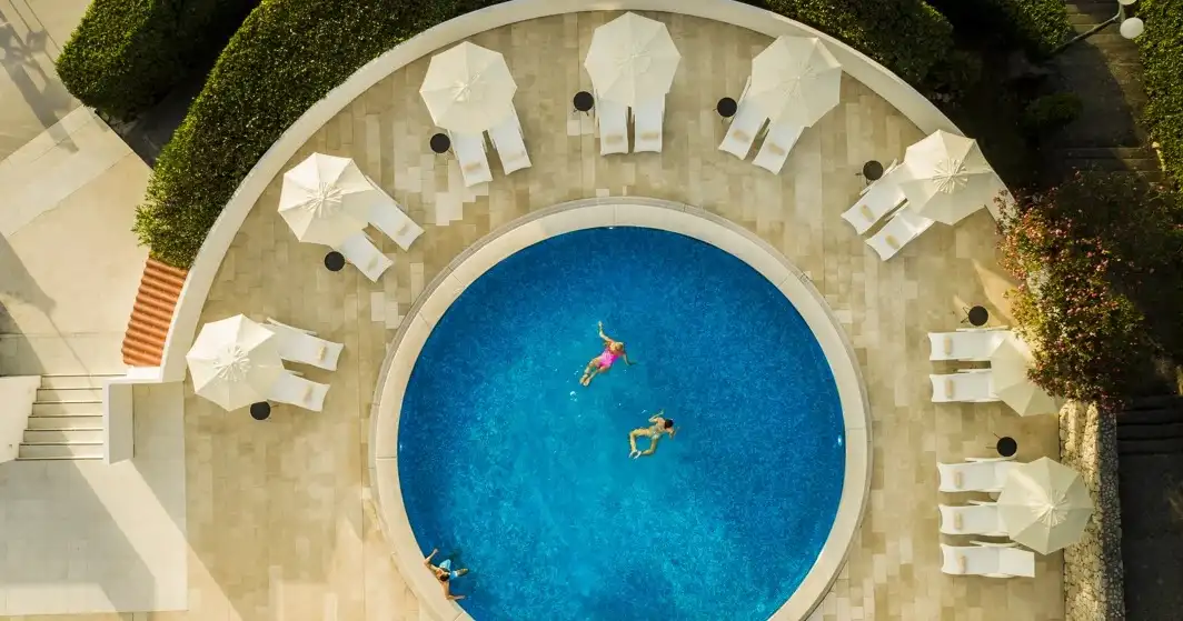 Hotel Liburna aerial view of a round pool ringed by white parasols