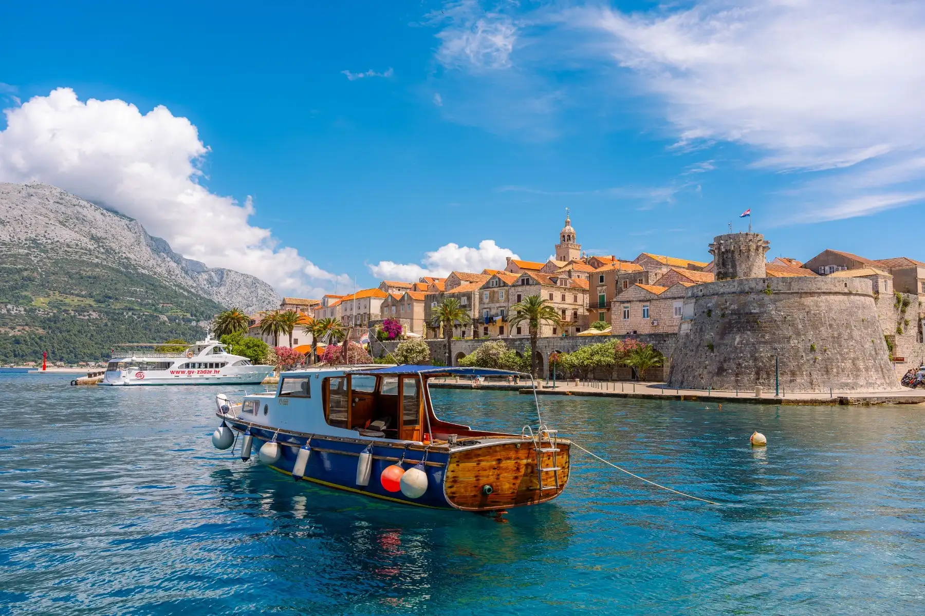 Hotel Liburna walled old town and wooden boat seen across the harbour