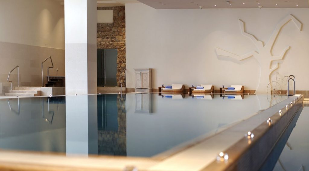 Hotel Excelsior indoor infinity pool with loungers and white walls