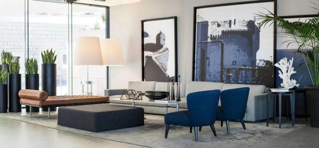 Hotel Excelsior lounge with blue armchairs and large black-and-white photographs